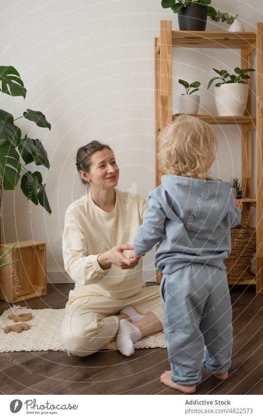 Glückliche Frau spielt mit kleinem Sohn Kind spielen Zusammensein Mutter Kindheit Mutterschaft Stock heimwärts jung Kleinkind blond lässig Barfuß bezaubernd