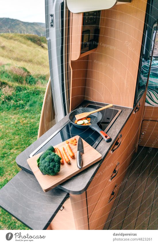 Vegane Mahlzeitenzubereitung in einem Wohnmobil Draufsicht Veganer Vorbereitung Essen zubereiten Gemüse keine Menschen niemand Schneidebrett Messer Zucchini