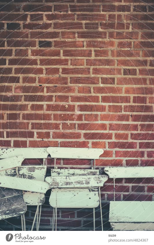 Mit dem A**** an der Wand Ziegelsteinwand Fassade Mauer Menschenleer alt trist Stuhl Sitzgelegenheit Sitzgruppe Möbel Stuhllehne Farbfoto Außenaufnahme weiß