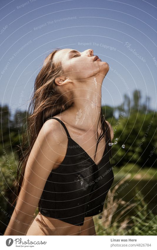 Ein entspanntes Mädchen an einem heißen Sommertag. Ihr nasses Hemd und ihr hübsches Gesicht fallen sofort ins Auge. Lange braune Haare und das Gefühl von sorglosem, wildem Sommer.