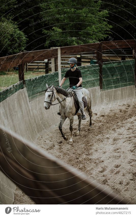 Mann reitet Pferd auf der Koppel Tier züchten heimisch schnell Freiheit Spaß galoppieren glühend grün Reiten Reithelm Pferderücken Landschaft Lifestyle