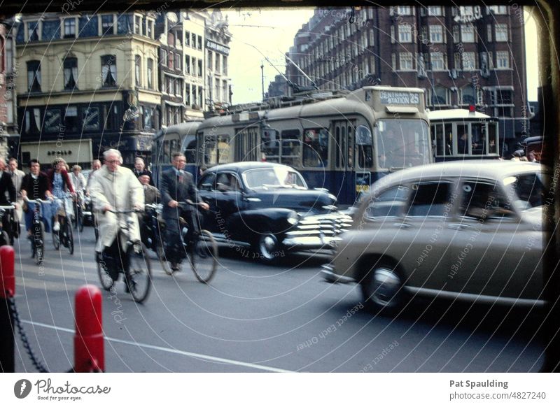 Fahrräder, Autos und Busse auf der Straße in Amsterdam, Holland in den 1950er Jahren Fahrradfahrer holländisch Stadtbild malerisch Altstadt Gebäude Architektur