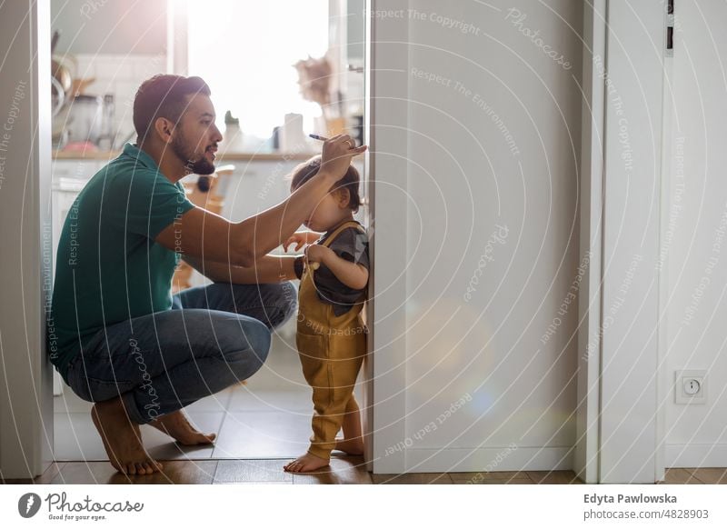 Papa kümmert sich zu Hause um seinen kleinen Sohn Erwachsener Zuneigung Baby Bonden Junge offen Pflege Kind Kindheit heimisch genießend Familie Spaß