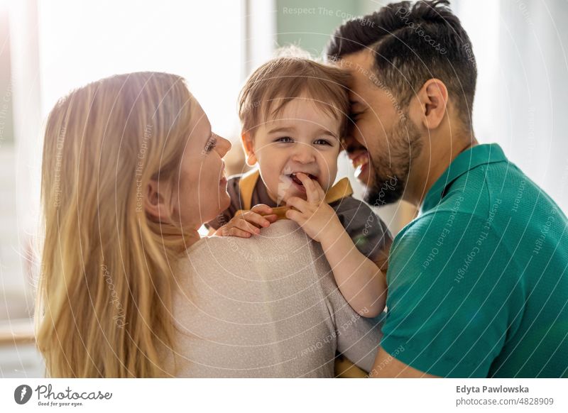 Junge Eltern spielen mit ihrem Kind zu Hause Wochenende spielerisch Mama Mutter Vater heimisch positiv Spielen Freizeit genießend Erwachsener Zuneigung Baby