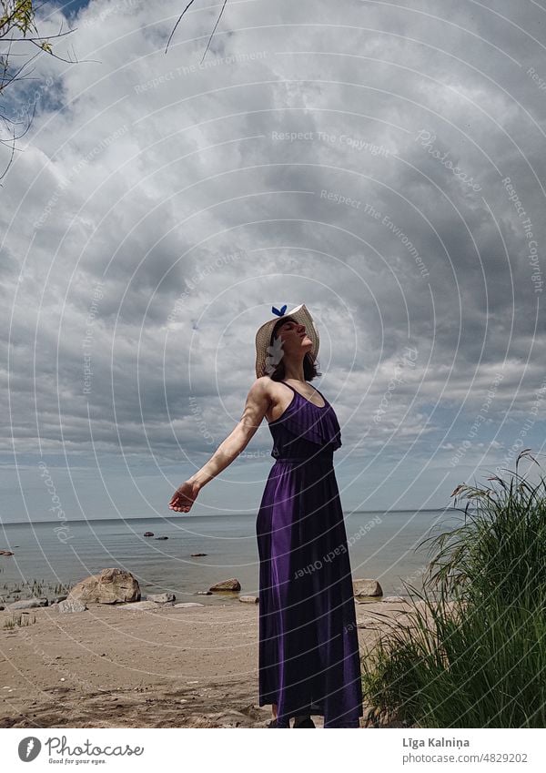 Frau am Strand Bewegung purpur Mode Tanzen malerisch Kleid Sommerhut Sommerurlaub Himmel Einsamkeit Szene ruhig Ausflugsziel Landschaft Textfreiraum abgelegen