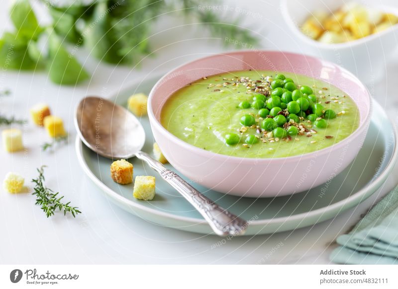 Gesunde Erbsencremesuppe in einer Schüssel Suppe grün Sahne Gemüse Vegetarier Püree Gesundheit Licht Diät Brot Würfel Schalen & Schüsseln Löffel Garnierung