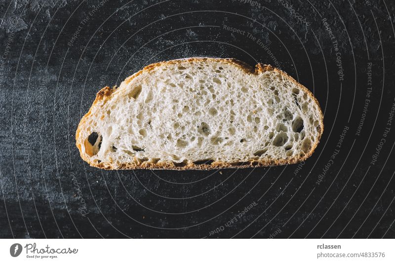 Brotscheibe auf dunklem Hintergrund Top Ansicht Scheibe hölzern Tisch Direkt darüber Roggen backen dunkel rustikal frisch Lebensmittel braun organisch