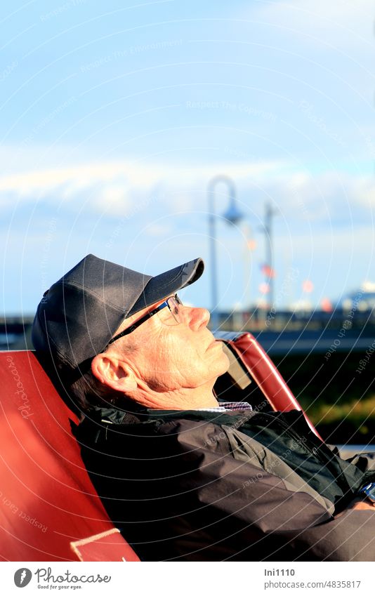 Senior genießt Frühlingssonne Mensch männlicher Senior Seitenprofil Mann Liegestuhl Sonnenbad Wärme spüren Zufriedenheit kurze Pause entspannen genießen