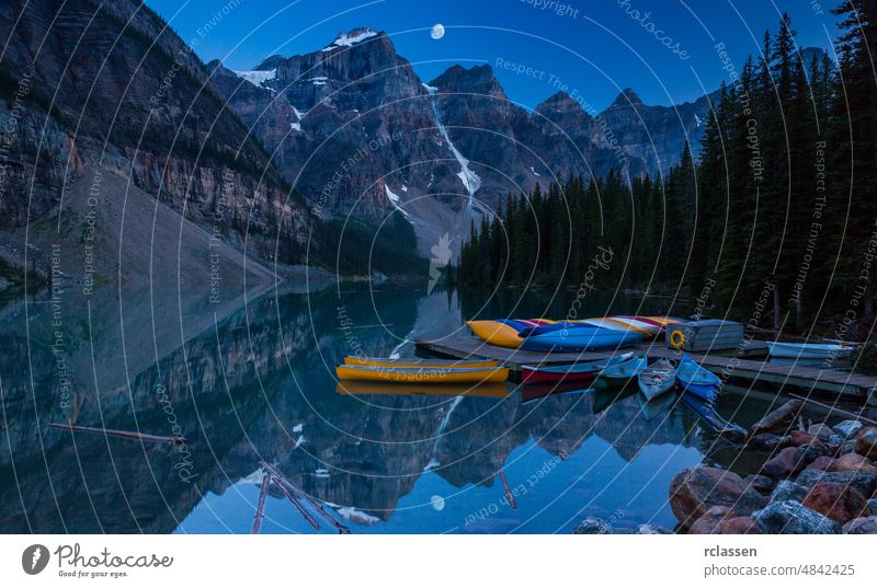 Kanus auf einem Steg am Moraine Lake, Banff-Nationalpark in den Rocky Mountains bei Nacht mit Mond, Alberta, Kanada national Park Gletscher Morgen See felsig