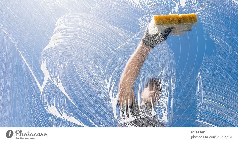 Fensterreiniger, der an einem sonnigen Tag das Fenster mit einem Schwamm putzt Sauberkeit Dienst Waschen Rakel Glas Waschmaschine Seife durchsichtig blau