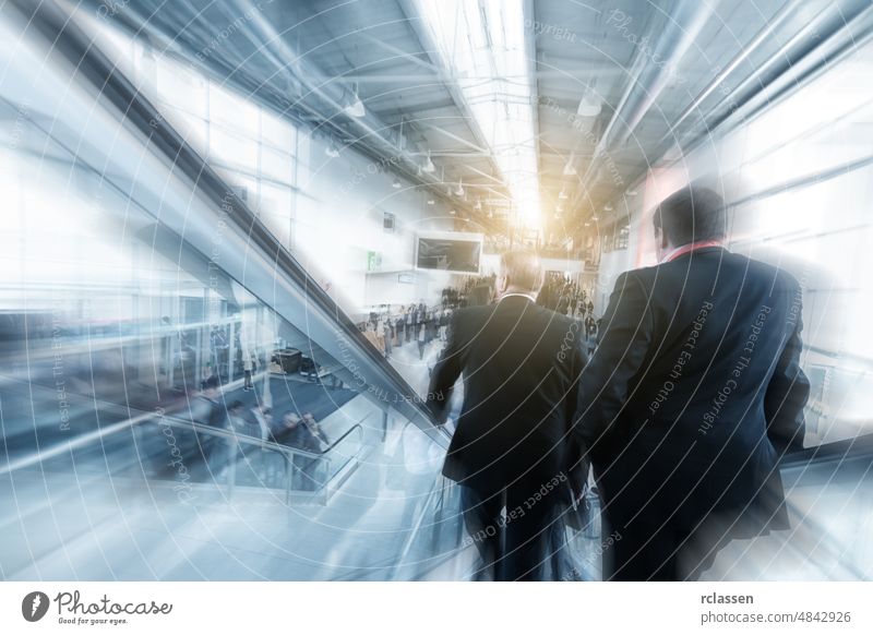 Unscharfe Geschäftsleute, die eine Rolltreppe auf einer Messe benutzen Architektur Besucher bewegend Business Berlin Gang Frankfurt am Main Menschen Fairness