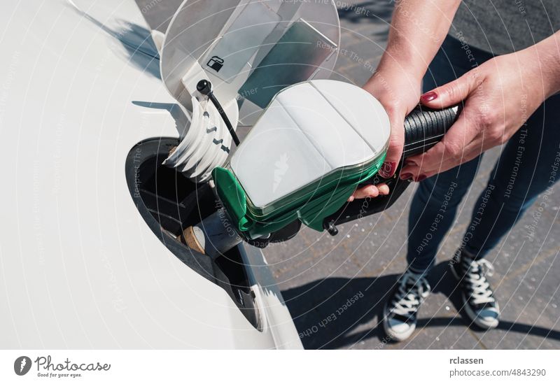 Junge Frau beim Tanken an einer Tankstelle Gas Station Brennstoff PKW Brotbelag Benzin Erdöl Pumpe besetzen Dienst Wirtschaft Energie Betankung reisen Fahrzeug