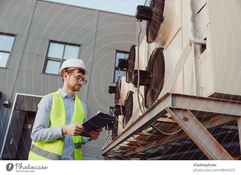 Kundendiensttechniker in Uniform bei der Inspektion einer industriellen Kälteanlage Konditionierer Kühler Ingenieur Flugzeugwartung Technologe Vorrichtung hvac