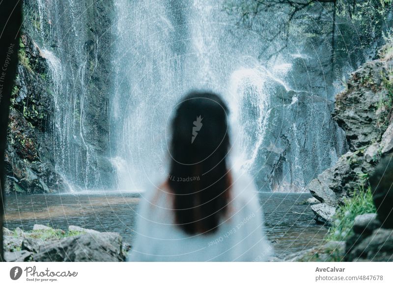 Unscharf junge Frau ausruhen und suchen einen Wasserfall, Meditation, Yoga und Denken Konzepte. Freiheit in der Natur, unabhängigen Lebensstil und Freiheit Konzept. Natürliche Parade und reine Luft Konzept.