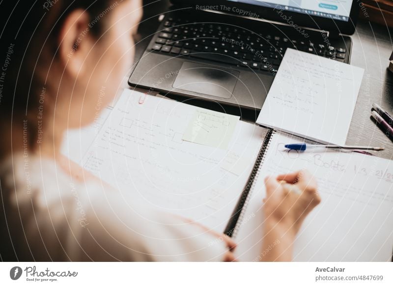 Close up Detail Bild zurück von einer jungen Frau studiert und arbeitet an seinem Schreibtisch zu Hause, Hausaufgaben während der Universität, die Vorbereitung für die Prüfung mit Lehrbuch und Notizen, selektive Fokus auf den Bleistift.