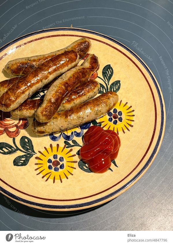 Teller mit Nürnberger Rostbratwürstchen und Ketschup Nürnberger Rostbratwurst Rostbratbwürstchen Fleisch Bratwurst Schweinefleisch Grillen Würstchen alt