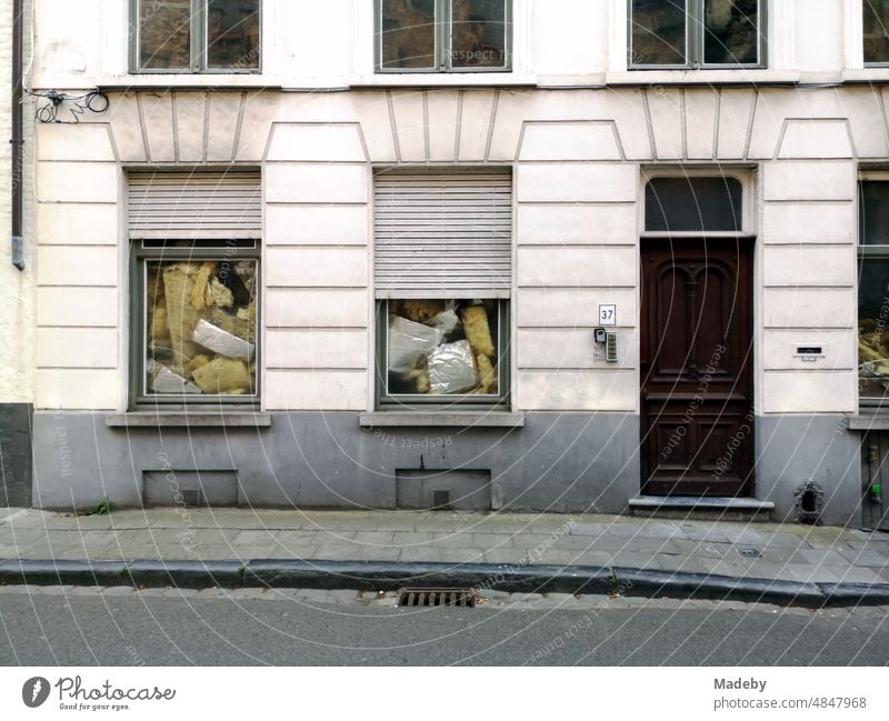 Ungehemmtes Dämmmaterial in Fenstern mit Rollladen eines schönen Altbau in Naturfarben in den Gassen der Altstadt von Brügge in Westflandern in Belgien Fassade