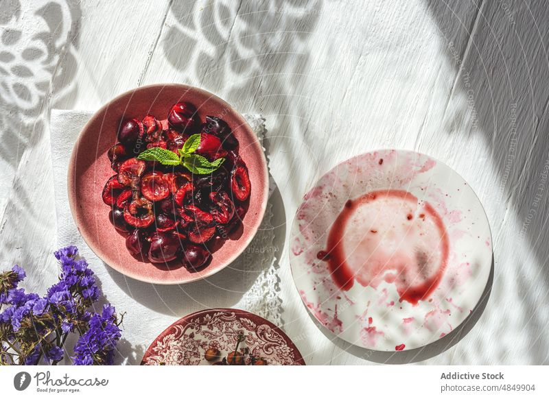 Kernlose halbe Kirschen auf dem Tisch Pasteten Kuchen Kruste rustikal serviert grün Feinschmecker Blume kulinarisch Grube Holz Rezept Minze rund frisch Beeren