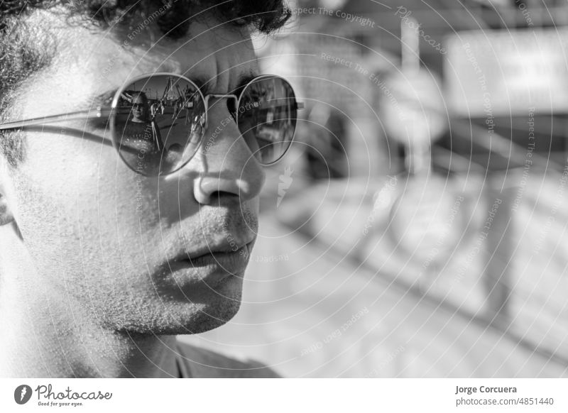 junger Mann mit Sonnenbrille und seine Mutter, die sich in seiner Sonnenbrille spiegelt, in einem Vergnügungspark. Porträt Person lässig Lifestyle Freizeit