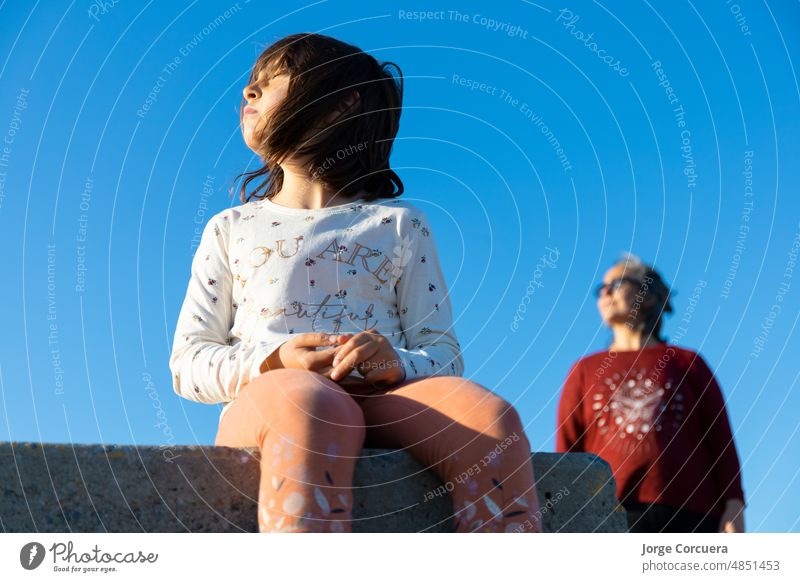 künstlerisches Porträt eines Mädchens und seiner Mutter, die an einem sonnigen Sommertag in die Sonne schauen, mit verschwommenem Hintergrund Gesicht Fotokamera