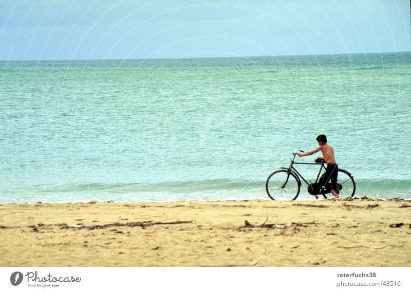 Hainan Dao Haikou China Daoismus Küste Strand Kind Fahrrad Wolken schieben Kurzhaarschnitt Asien Brandung ruhig Rauschen türkis Meer Verkehrsmittel gelb Ocker