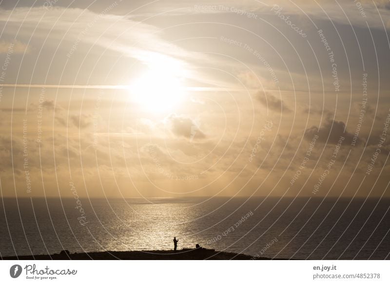 Es wird heiß Sonne Sonnenlicht Abendlicht Hitze Sommer Klima Klimakrise Sonnenuntergang Gegenlicht Mann Silhouette Meer Horizont Himmel Wolken Sonnenstrahlen