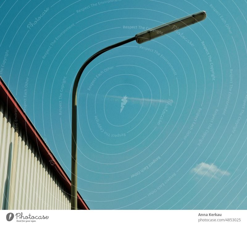 Eine Strassenlaterne vor einer Lagerhalle bei blauem Himmel Straßenlaterne Straßenleuchte Straßenbeleuchtung Straßenlampe Klarer Himmel Blauer Himmel werkshalle