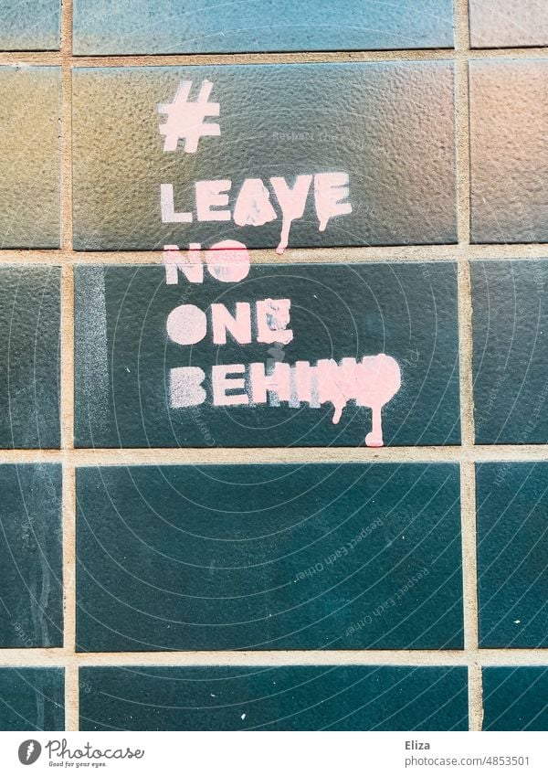 Leave no one behind Graffiti an einer Hauswand leave no one behind Geflüchtete rosa gesprayed Typographie seenotrettung Solidarität Hilfe Schrift politisch