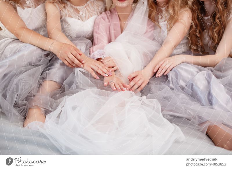 elegante Braut mit Brautjungfern in der Hochzeit Morgen Vorbereitung. Schöne Braut ist bis eine elegante Hochzeit Robe, Brautjungfern in grauen Kleidern gekleidet