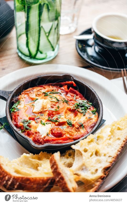 Shakshuka in Eisenpfanne, serviert mit Brot shakshuka shakshouka Zwiebel Lebensmittel Frühstück Vegetarier Gesundheit Mahlzeit traditionell Paprika gebraten