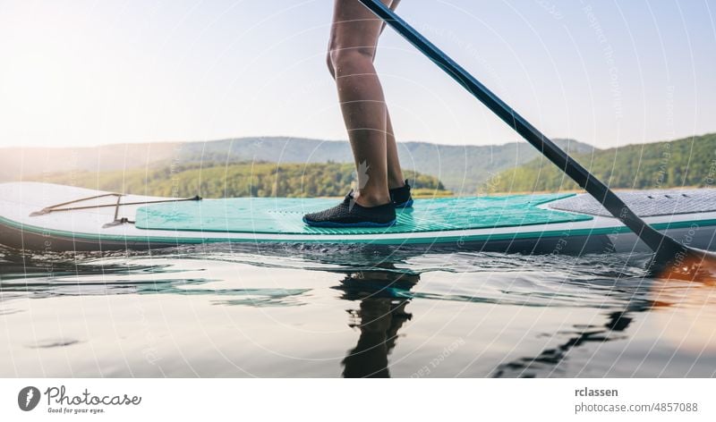 Standup-Paddler auf dem See im Sommer Paddel Holzplatte stehen nach oben Paddelbrett Sport Wasser Abenteuer SUP Frau Wassersport Brandung Erholung reisen Spaß