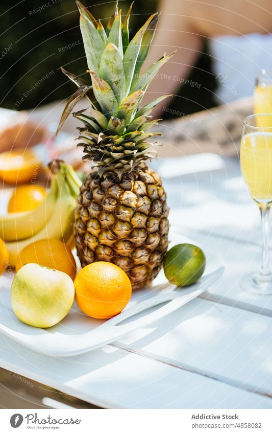 Frisches Obst auf dem Tisch im Innenhof Ananas Frucht tropisch exotisch Zitrusfrüchte Banane Getränk trinken Terrasse patio Sommer frisch Gesundheit Vitamin