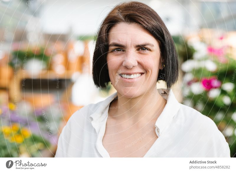 Glückliche erwachsene Frau im Blumenladen Werkstatt Lächeln freundlich Klient Verkäufer Porträt brünett Erwachsener heiter Laden Kurze Haare froh positiv