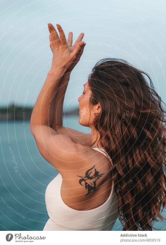 Ruhige Dame am Meeresufer in Ardha Chandrasana Yoga-Pose stehend Frau Berg-Pose Asana MEER Wellness Natur Achtsamkeit Stressabbau Wohlbefinden Strand jung