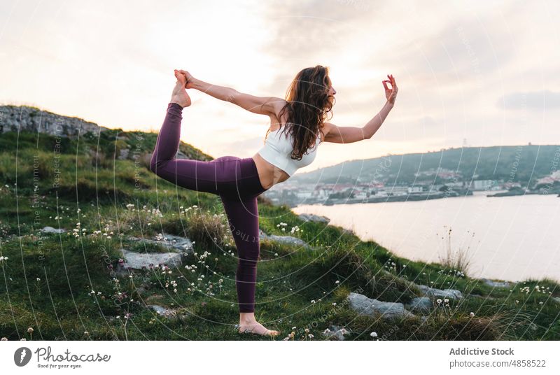 Barfüßige Dame bei der Asana "Stehender Bogen" auf einem felsigen Hügel Frau Yoga Gleichgewicht stehender Bogen Berge u. Gebirge Dehnung Dandayamana Dhanurasana