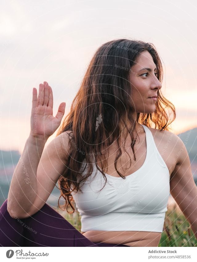 Sportlerin beim Dehnen in der Natur Athlet Dehnung Frau Sportbekleidung Gras Wiese meditieren Sonnenuntergang Yoga Sportkleidung üben Training Übung sitzen grün