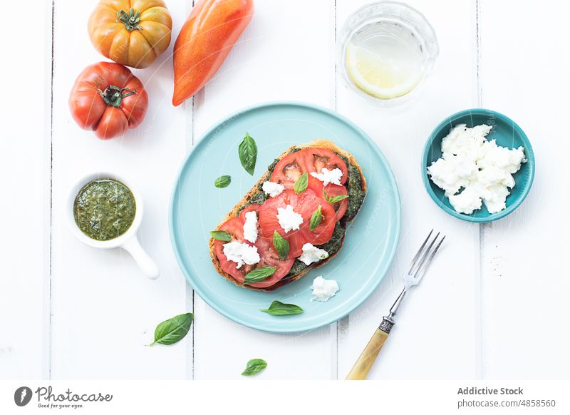 Caprese-Toast auf Holztisch serviert Zuprosten Tomaten Brot lecker Pesto-Sauce Erdöl Salatbeilage Snack Belegtes Brot Gemüse Mozzarella Käse frisches Basilikum