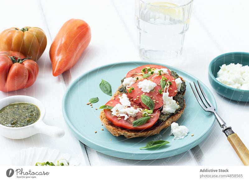 Caprese-Toast auf Holztisch serviert Zuprosten Tomaten Brot lecker Pesto-Sauce Erdöl Salatbeilage Snack Belegtes Brot Gemüse Mozzarella Käse frisches Basilikum