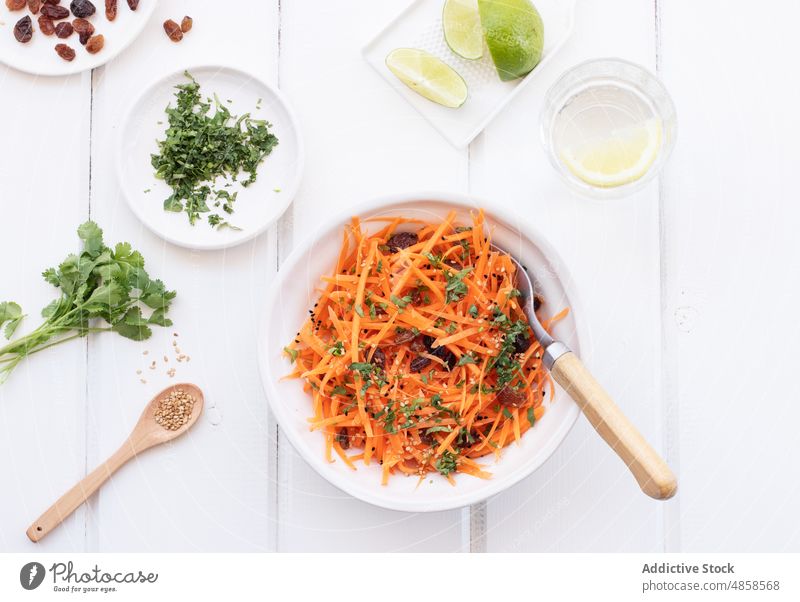 Geriebener Karottensalat auf Holztisch Vegetarisches Essen selbstgemacht Kalk Koriander Petersilienblatt Rohkost Snack Tisch niemand Mittagessen gerieben