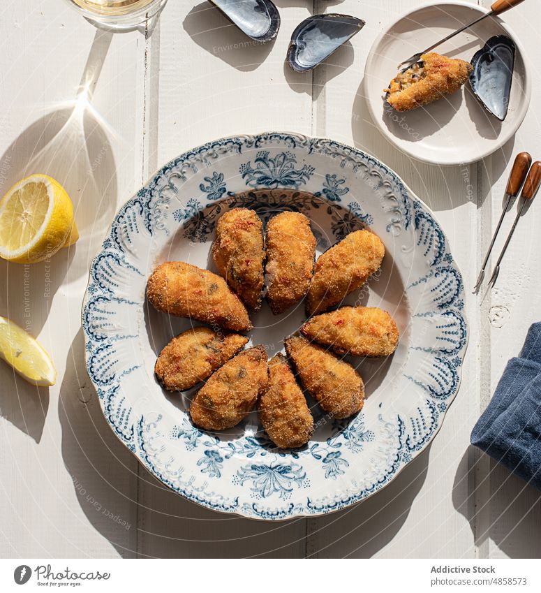 Frische gefüllte Muscheln in einer Schale auf einem Holztisch Zitrone spanische Tapas Tapas-Essen Panzer Muschelschale Lebensmittelhintergrund Abendessen