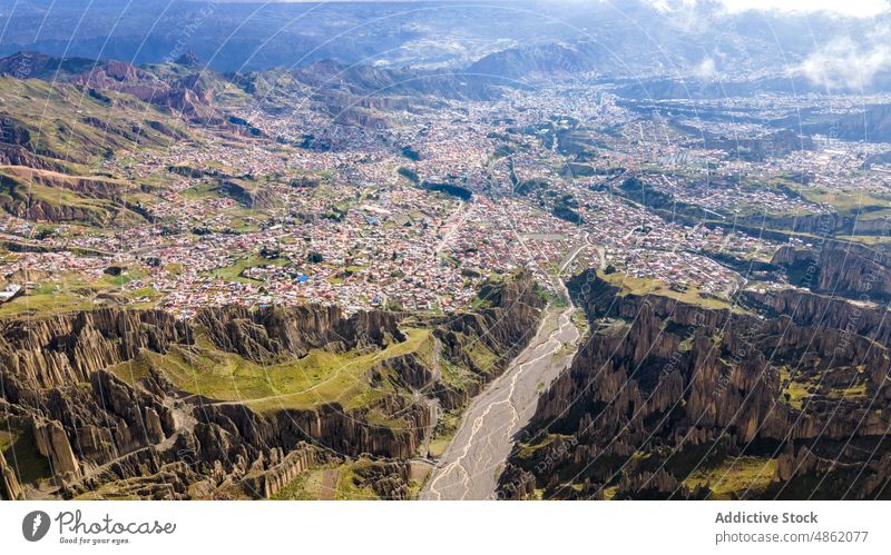 Drohnenansicht eines gebirgigen Tals mit einer Siedlung im Sonnenlicht Berge u. Gebirge Stadt Landschaft Klippe Kamm Schlucht atemberaubend Hochland malerisch