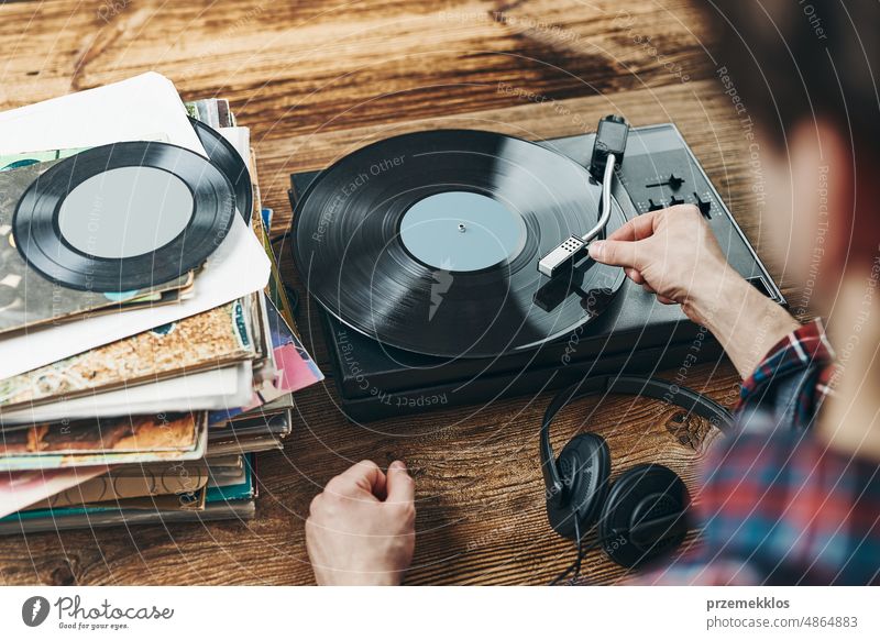 Mann hört Musik von einer Schallplatte. Abspielen von Musik von einer analogen Platte auf einem Plattenspieler. Genießt Musik aus einer alten Sammlung. Retro und Vintage