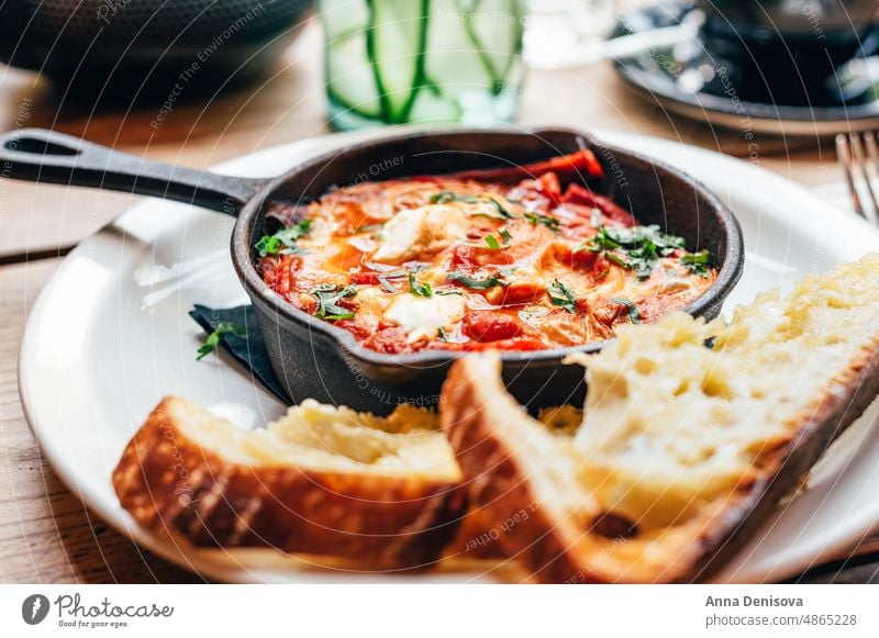 Shakshuka in Eisenpfanne, serviert mit Brot shakshuka shakshouka Zwiebel Lebensmittel Frühstück Vegetarier Gesundheit Mahlzeit traditionell Paprika gebraten