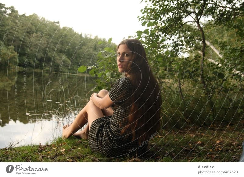 Wächterin Junge Frau Jugendliche Beine 18-30 Jahre Erwachsene Natur Baum Sträucher Wald Seeufer Kleid Barfuß brünett langhaarig Blick sitzen natürlich dünn