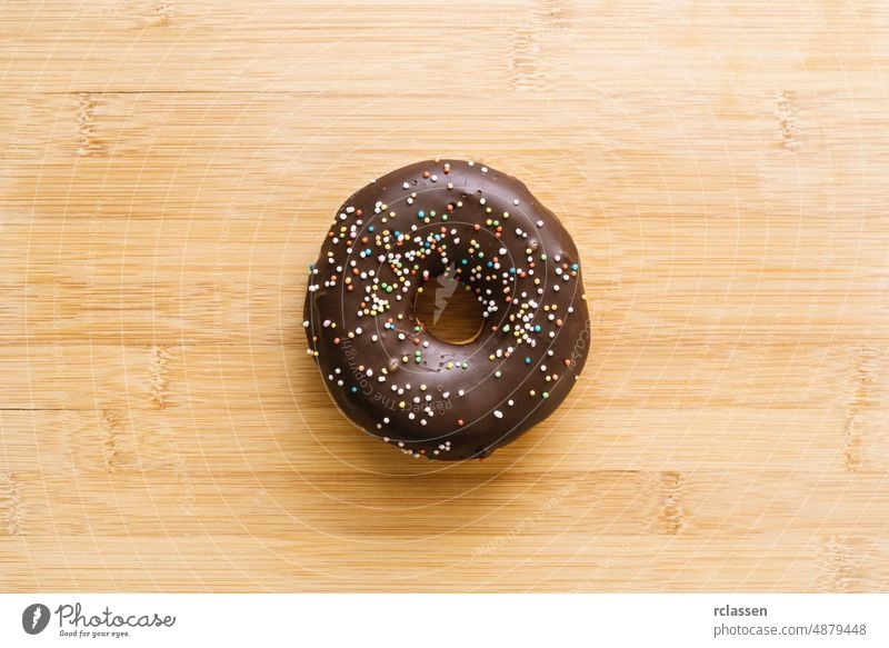 Donut mit Schokoladenglasur und Streuseln. direkt über der Aufnahme Krapfen Doughnut gebacken Bäckerei rosa Dessert Lebensmittel Zucker sortiert Hintergrund