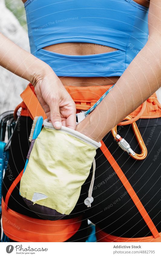 Frau, die Kreidepulver aus dem Beutel nimmt Pulver vorbereiten Klettern Aufsteiger Wanderer Bergsteigen Sport Mittelteil Kabelbaum Stehen Rückansicht wandern