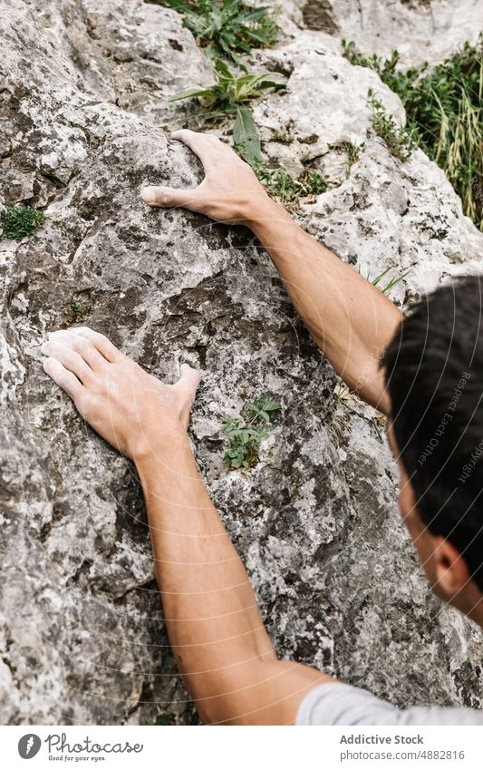 Abgeschnittene Hände, die nach einem Felsen greifen Wanderer Griff Klippe felsig Pulver Aufsteiger Hand Kreide Sport Klettern Bergsteigen wandern Abenteuer