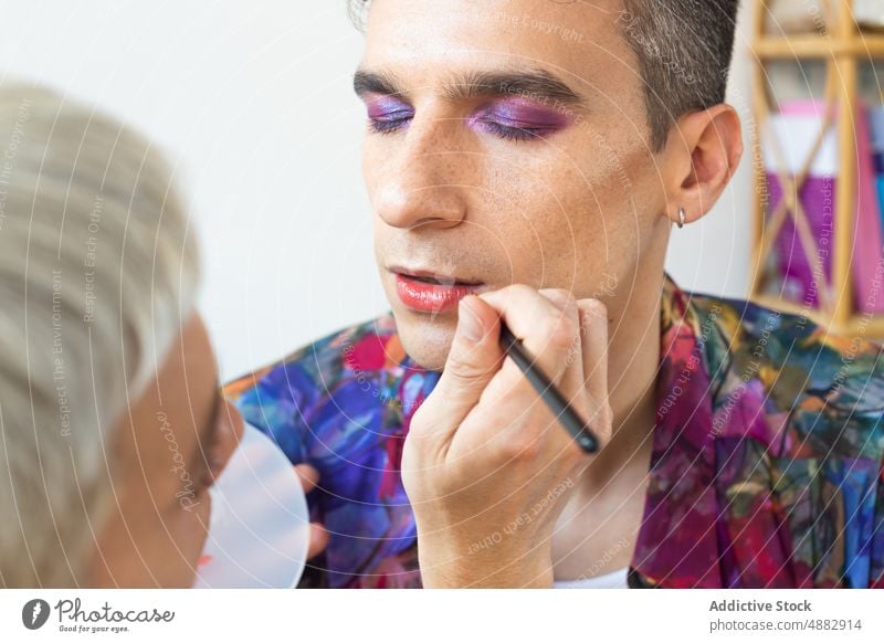 Transgender-Mann, der von seinem Freund geschminkt wird Paar anwendend Lidschatten Künstler Kosmetik schwul Make-up Waschtisch Bürste Zusammensein Palette