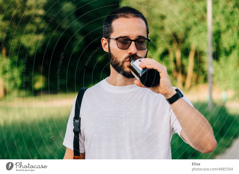 Mann im T-Shirt trinkt draußen ein Bier aus der Flasche trinken Biertrinken Alkohol Getränk Bierflasche Durst Brille Bart jung Sommer Craft-Bier Genuss