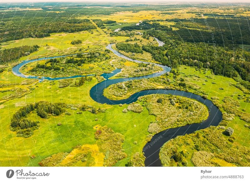 Luftaufnahme Grüner Wald Wälder und Flusslandschaft im sonnigen Frühling Sommer Tag. Top View of Beautiful European Nature From High Attitude In Autumn Season. Drone Ansicht. Vogelperspektive Ansicht